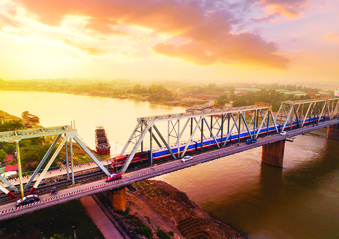 The Thong Nhat railway passes through a large river at sunset