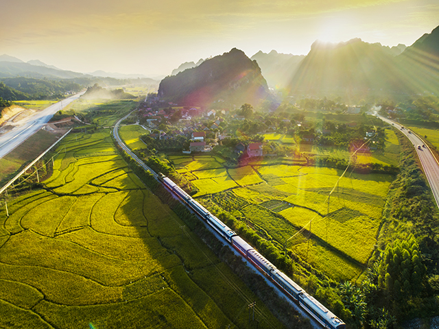 Vietnam Thong Nhat train passes through rice fields and mountain ranges in Ninh Binh province